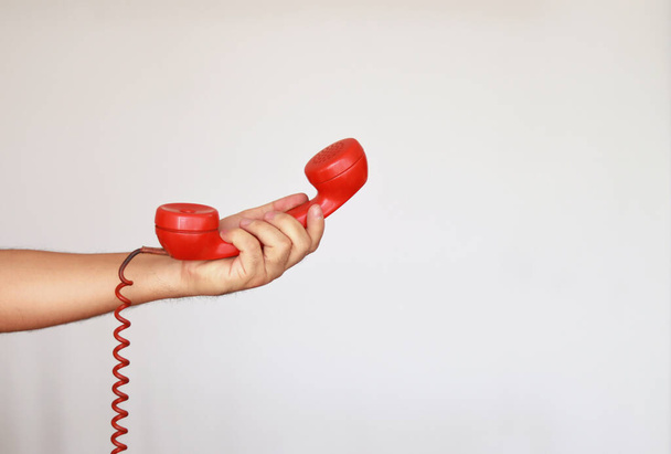 Átadni egy régi vintage piros telefon fehér háttér  - Fotó, kép