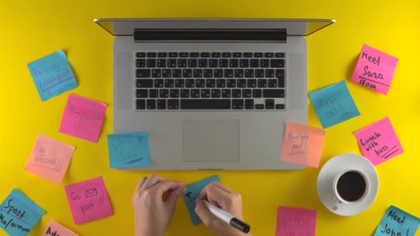 新しいメモを作成し、それを紙に書き、オフィスの机のラップトップ - 映像、動画