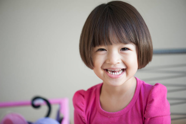 Gelukkig Aziatisch meisje met een grote glimlach en lachen. Vrolijke glimlach grappig gezond gezicht jong schattig vrouwelijk kind. Vrolijk Aziatisch meisje portret. Ruimte voor tekst. - Foto, afbeelding