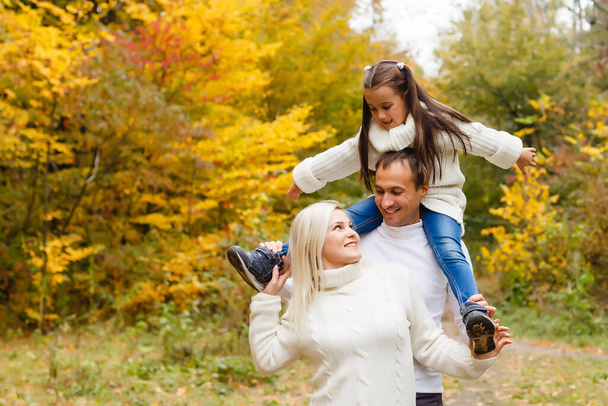 family, childhood, season and people concept - happy family in autumn park - 写真・画像