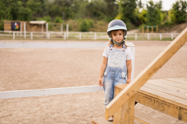 niña jinete de caballo en el casco en el hipódromo - Foto, Imagen