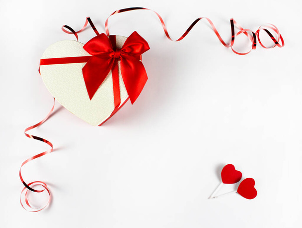 Valentin-napi fogalom Valentin-nap. Piros rózsa szirmokkal, fehér háttérrel. Valentin-nap, Valentin-nap, bannerek, képeslap. Ajándék és szalag. másolótér - Fotó, kép