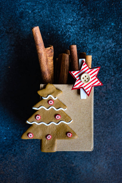 Karácsonyi kártya koncepció fahéjas botokkal és ünnepi dekorációval sötét hangulatban - Fotó, kép