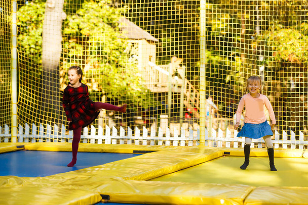 Joyeux écolière sautant sur le trampoline dans le parc d'automne - Photo, image