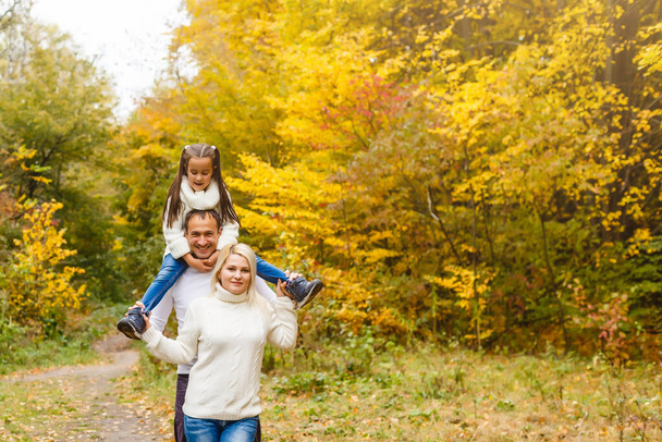 Familia con niño ir en el parque de otoño - Foto, imagen