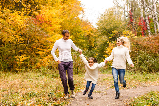 family, childhood, season and people concept - happy family in autumn park - Photo, Image