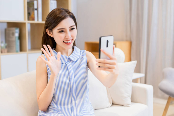 asian young woman has video chat with friends by smart phone in living room at home - Фото, зображення