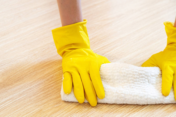 Close-up of a girls hands washing the floor in a bright room in yellow household gloves. Clean and fresh. - Фото, зображення