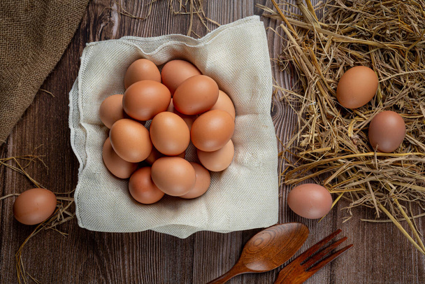 Αυγά σε κούπες σε λινάτσα με στεγνό γρασίδι. - Φωτογραφία, εικόνα