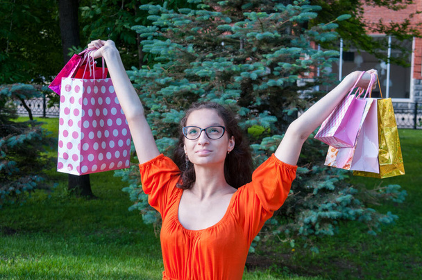 The brunette in glasses has lifted bags on hands upwards - Foto, Imagem