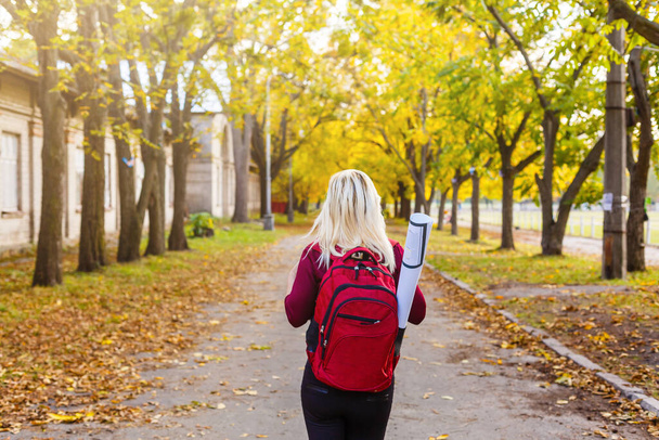 girl with a backpack in the autumn park - Foto, Bild