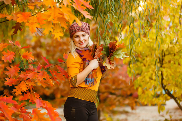 Fashion vrouw in de herfst park met geel blad - Foto, afbeelding