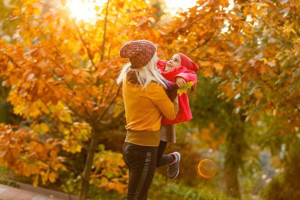 portret młodej kobiety i jej córki w jesiennym parku - Zdjęcie, obraz