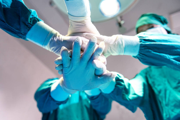 Cirurgião de grupo médico unindo as mãos antes da cirurgia do paciente no centro cirúrgico do hospital. Trabalho em equipe médico que trabalha com cirurgia - Foto, Imagem