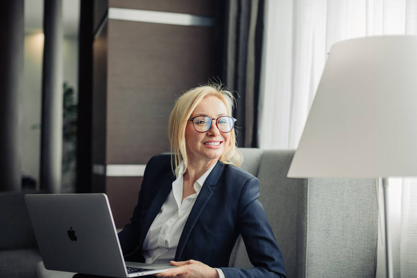 Portrait of a attractive blonde business woman at office working on laptop - Foto, Imagem