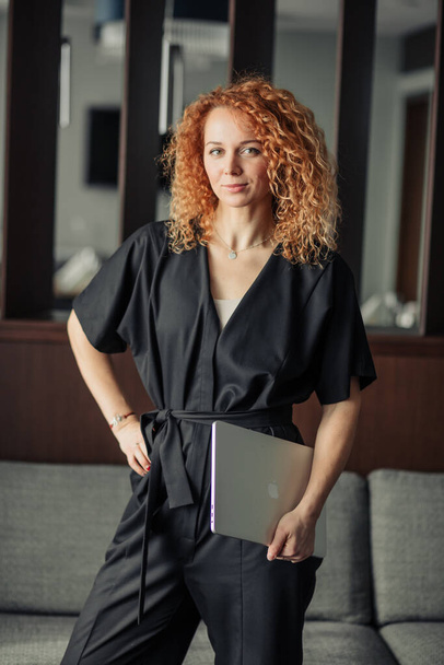 Kobieta blogger z kręconymi rudymi włosami chętnie uczestniczyć w ciekawym spotkaniu - Zdjęcie, obraz