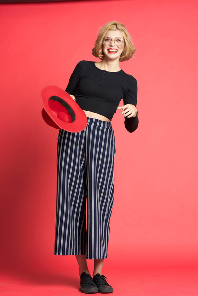 Pretty woman with red hat fashionable clothes pink isolated background glamor - Fotó, kép