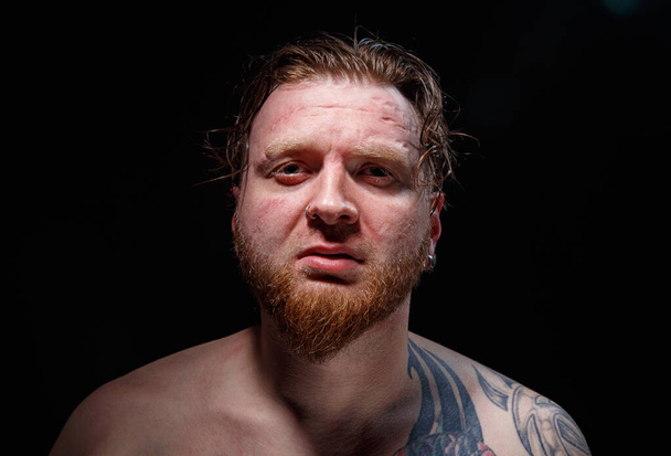 Retrato de hombre tatuado con pelo rojo sobre fondo negro - Foto, Imagen