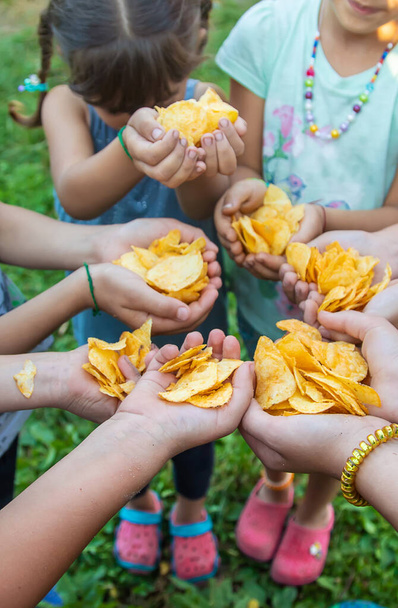 Kinder halten Chips in der Hand. Selektiver Fokus. Menschen. - Foto, Bild