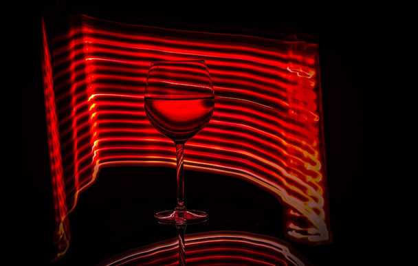 Bodegón de una copa, botella, vino, hecho en la técnica de dibujo con luz - Foto, Imagen