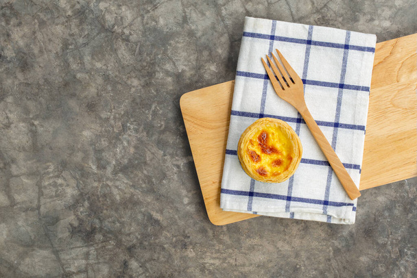 dessert eiertaart of Portugal ei taart zoete vla crème op houten plank en helder grijs beton achtergrond, bovenaanzicht - Foto, afbeelding