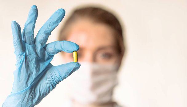 Doctor holding a pill, looking at it and giving it as a treatment to the patient - Photo, Image