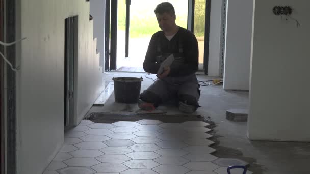 Amateur worker lay floor hexagon tiles at home - Footage, Video