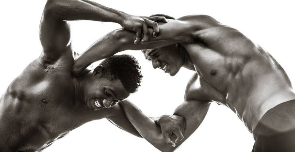 Güçlü üstsüz siyah erkek sporcular güreşiyor. Güç ve rekabet. Siyah ve beyaz. - Fotoğraf, Görsel