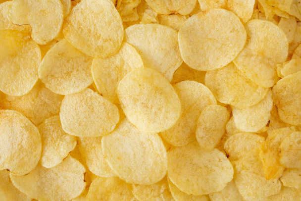 krokante aardappel chips snack textuur achtergrond bovenaanzicht - Foto, afbeelding