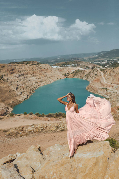 fashion outdoor photo of beautiful sexy woman with blond hair in luxurious dress posing in beautiful landscape with lake view - Photo, image
