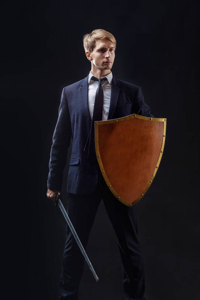 Manager with shield and sword protects business, the concept of crisis management - Fotografie, Obrázek