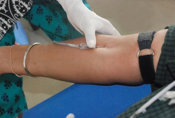 blood donation. female doctor tacking blood on man hand. - Photo, Image