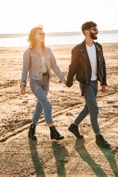 Happy young couple spending fun time together at the sunny beach, walking - Foto, Imagen