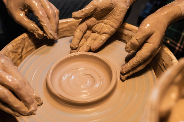 teacher and student sculpt a pot of clay on a Potters wheel, close-up. - Photo, Image