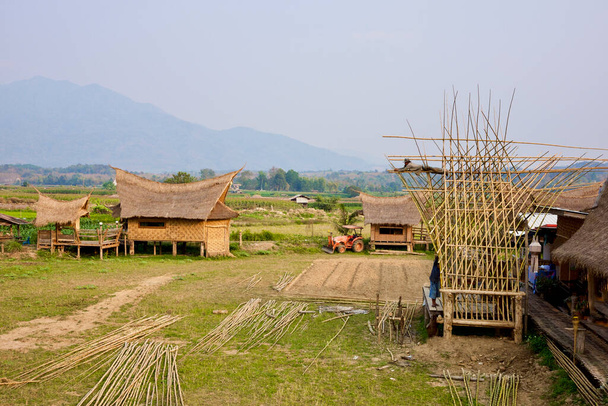 Casa arquitectónica local con diseño de techo único y en construcción estructura de bambú en la montaña de primer plano en el fondo en la región norte de Tailandia - Foto, Imagen