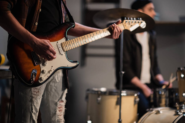 σόλο και ρυθμικό κιθαρίστα με το συγκρότημα και την κιθάρα του κοντά σε μια υπόγεια συναυλία. - Φωτογραφία, εικόνα