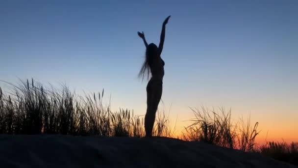 Femme méconnaissable faisant du yoga dans la soirée venteuse - Séquence, vidéo