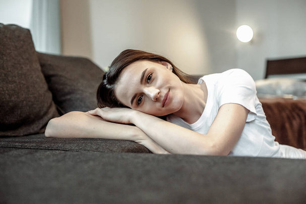 Young woman pretty relaxing on couch in living room. Casual style indoor shoot - Foto, Imagem
