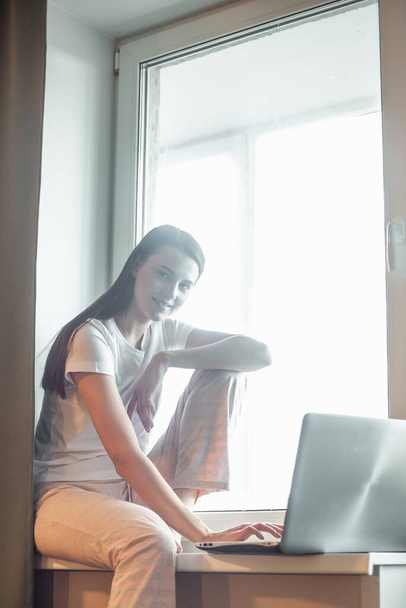 Girl working on computer laptop in light room. Woman chat in social network via net-book in modern interior - Fotografie, Obrázek