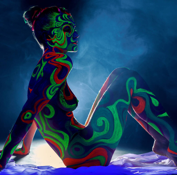 Girl with body art glowing under ultraviolet light - Foto, afbeelding