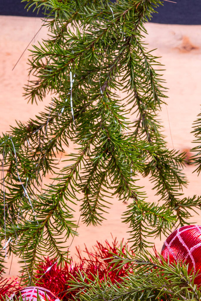 Fir ágak játékok piros üveg labda, tinsel egy könnyű fa hátter.Karácsonyi kártya.Csendélet - Fotó, kép