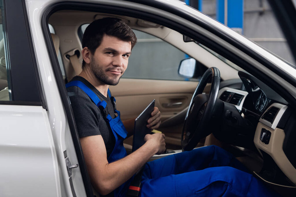 Un trabajador de servicios de automóviles que revisa el interior de un coche - Foto, Imagen