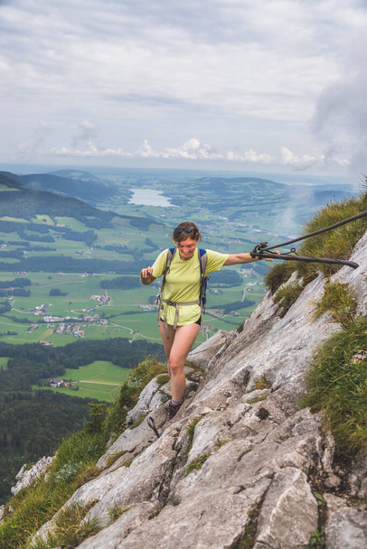 Young slim backpacker tourist girl climbing on rocky mountain, Austria - Φωτογραφία, εικόνα