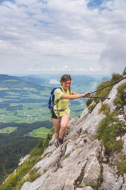 Young slim backpacker tourist girl climbing on rocky mountain, Austria - Foto, afbeelding