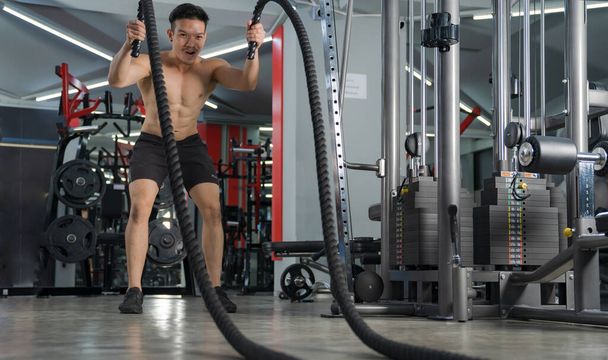Man working out with battle ropes at gym, Functional training, Sport fitness training, Lifestyle people concept - Photo, Image