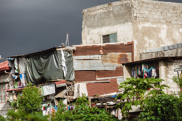 Zbliżenie chwiejnego domu z blachy stalowej i betonowych pustych bloków w strefie slumsów. - Zdjęcie, obraz