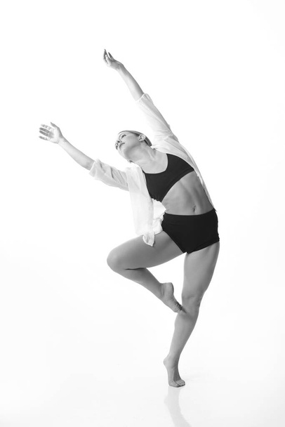 Joven hermosa bailarina posando en un fondo de estudio. Blanco y negro. Aislado - Foto, Imagen