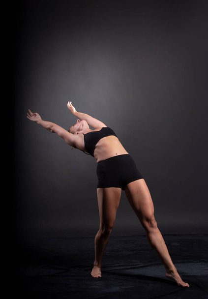 Stüdyoda balerin dansı, siyah arka plan - Fotoğraf, Görsel