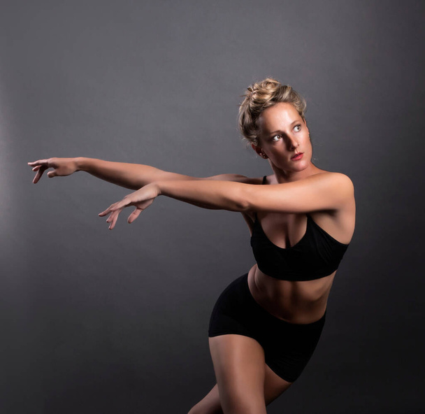 Bailarina dança no estúdio, fundo preto - Foto, Imagem