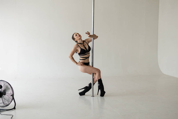 sexy pole dance from a young sophisticated girl of European appearance. Processional pole dancing - Foto, Imagen